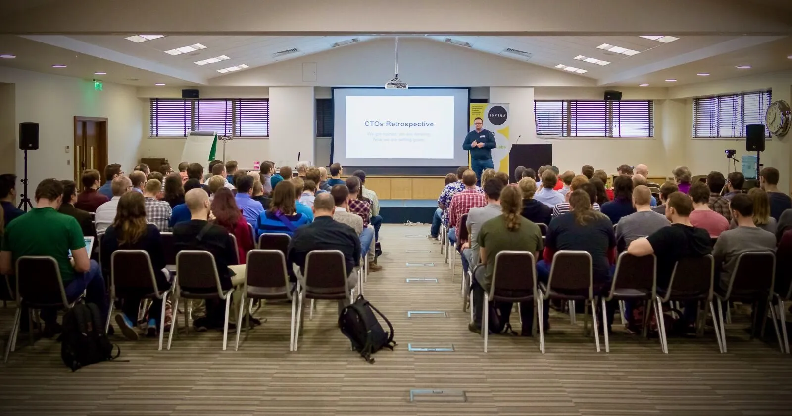 A speaker addressing a full room at a CTOs retrospective