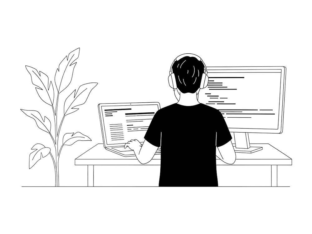 A developer at a desk building a prototype across a laptop and monitor